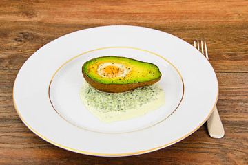 Avocados, baked with quail egg, salt, pepper, lemon