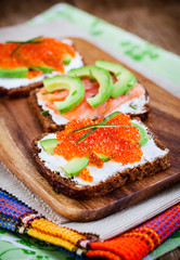 Appetizer with red caviar, avocado, salmon and creamcheese