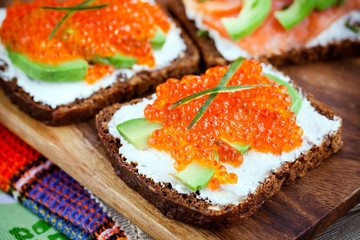 Appetizer with red caviar, avocado, salmon and creamcheese