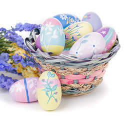 Colorful Easter Eggs, Flowers and Basket on a White Background