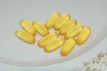 Omega 3 Fish oil food supplement capsules on plate