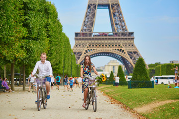 Obraz premium couple riding bicycles near the Eiffel tower in Paris