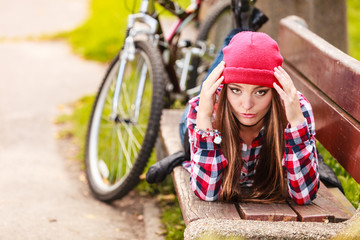 Fototapeta na wymiar girl relaxing in autumnal park with bicycle.