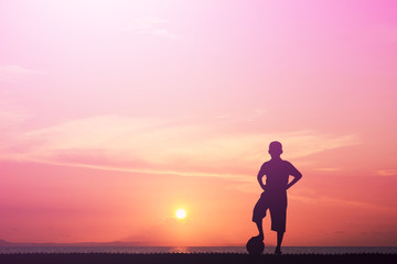 Silhouette of children playing soccer background sky