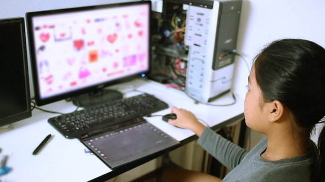 Asian teen using computer for doing home work at home 