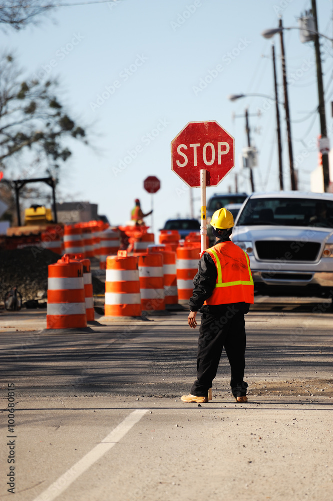 Wall mural worker holding stop sign in construction site on the street