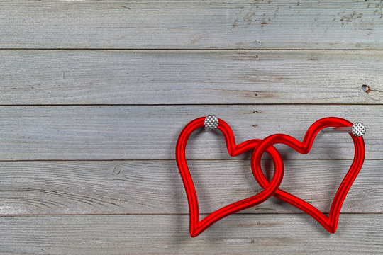 two linked red hearts against the planks background
