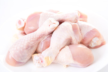 raw chicken drumsticks on white background