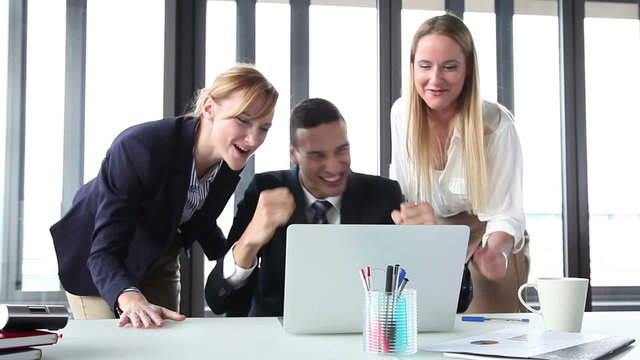 Young manager and two businesswoman with laptop, high-fiving and cheering