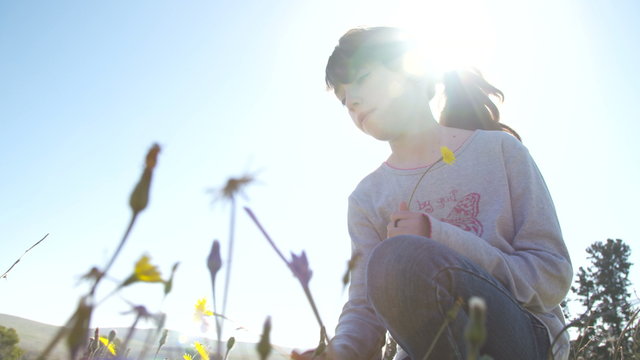 Girl smelling a dandelion in the sun 