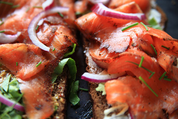 Smoked salmon, red onion, chives and lettuce on dark bread with grainy mustard