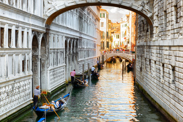 Fototapeta na wymiar Tourists in gondolas sailing under the Bridge of Sighs in Venice
