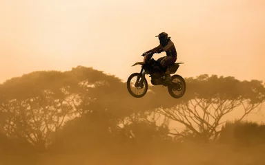 Zelfklevend Fotobehang silhouet van motorcrosser die op de baan springt © toa555