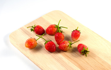Fresh strawberries on wooden and on white background