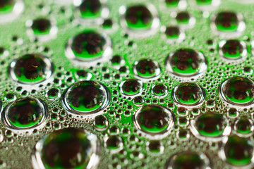 Water drops on green transparent glass