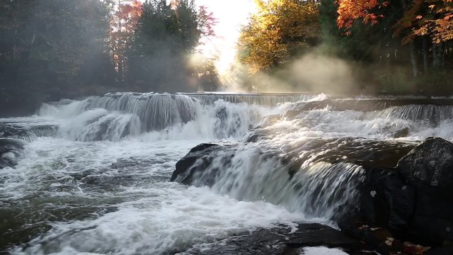 Loop features whitewater cascading over Bond Falls, a beautiful waterfall in Michigan Upper Peninsula, at dawn in the autumn with foggy mist.