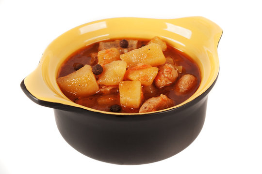 Stewed potatoes with meat in a ceramic pot.