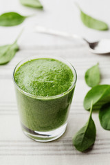 Green spinach smoothie in glass on white table, detox and diet food for breakfast