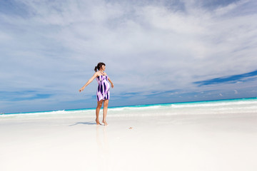 Pregnant woman walking on white beach
