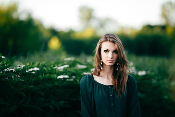 Beautiful young woman posing in a flowering spring park