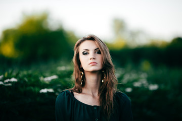 Beautiful young woman posing in a flowering spring park