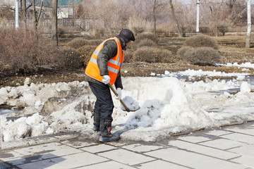 Мужчина убирает снег лопатой. Волг