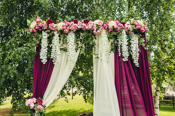 wedding arch with flowers on ceremony place