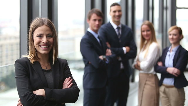 Portrait of beautiful businesswoman smiling, colleagues in background