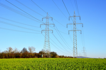 Freileitungsmasten am grünen Feld