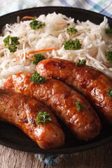 Sauerkraut with sausages on the table close-up. Vertical
