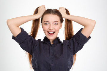 Funny excited young woman with two ponytails holded by hands