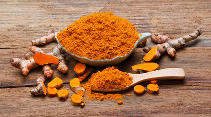 fresh turmeric roots on wooden table