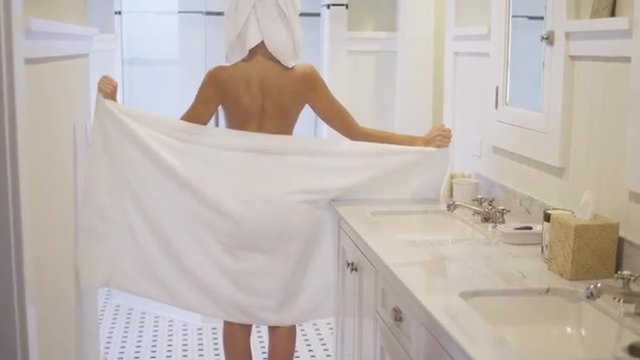 Gorgeous young mixed ethnic woman teasing camera wearing towel