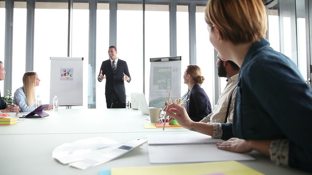 Smiling manager giving presentation to colleagues