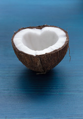 Chopped coconut: coconut halves in the shape of a heart on a blu