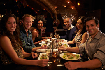 Group Of Friends Enjoying Meal In Restaurant