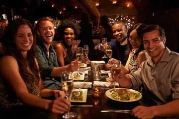 Group Of Friends Enjoying Meal In Restaurant