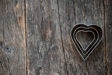 Heart shaped cookie cutter on a wooden background