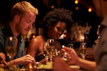 Group Of Friends Enjoying Meal In Restaurant