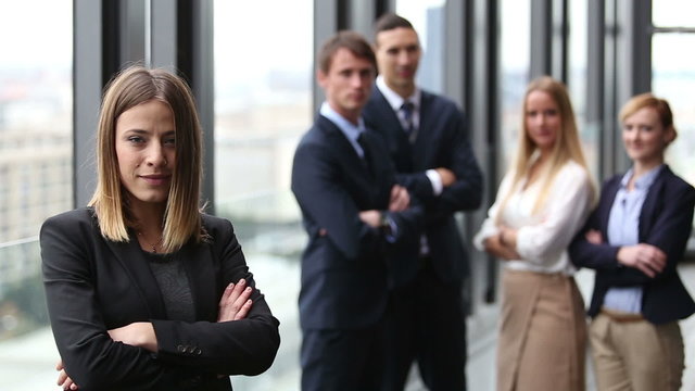 Portrait of beautiful businesswoman smiling, colleagues in background