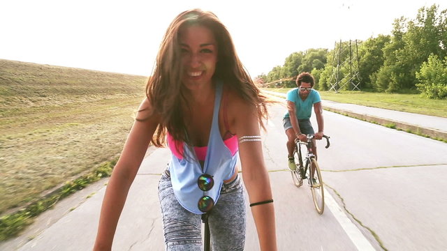 Slow motion of beautiful woman sending kisses while cycling with friends, graded