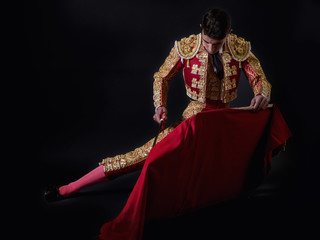 Young bullfighter, dressed in traditional costume to fight - obrazy, fototapety, plakaty