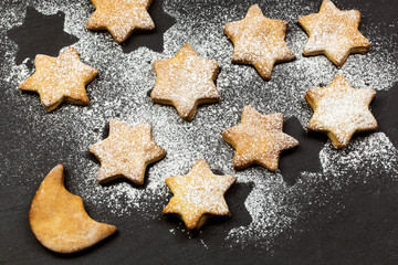 STARRY SKY MADE BY STARS AND MOON SHAPE COOKIES OVER SLATE