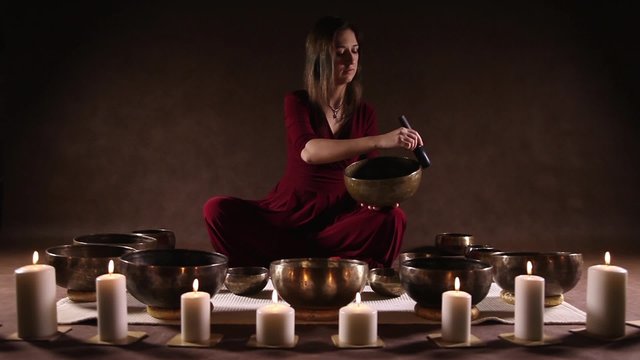 Woman playing a singing bowls also known as Tibetan Singing Bowls, rin gongs, Himalayan bowls or suzu gongs
