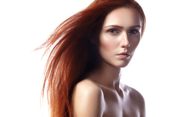 Beautiful ginger young woman with flying hair and naturel makeup. Beauty portrait of sexy model with straight red hair. Long soft shiny hairstyle. Close-up studio shot o fashion look redhead girl
