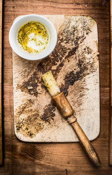 Oil marinate and brush on rustic gutting board, top view