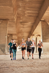 Urban runners training under a bridge