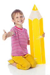 Happy kid with a big pencil in studio