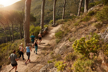 Group of people trail running on a mountain path - Powered by Adobe