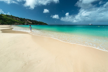 Fototapeta na wymiar Woman is walking in a Caribbean beach
